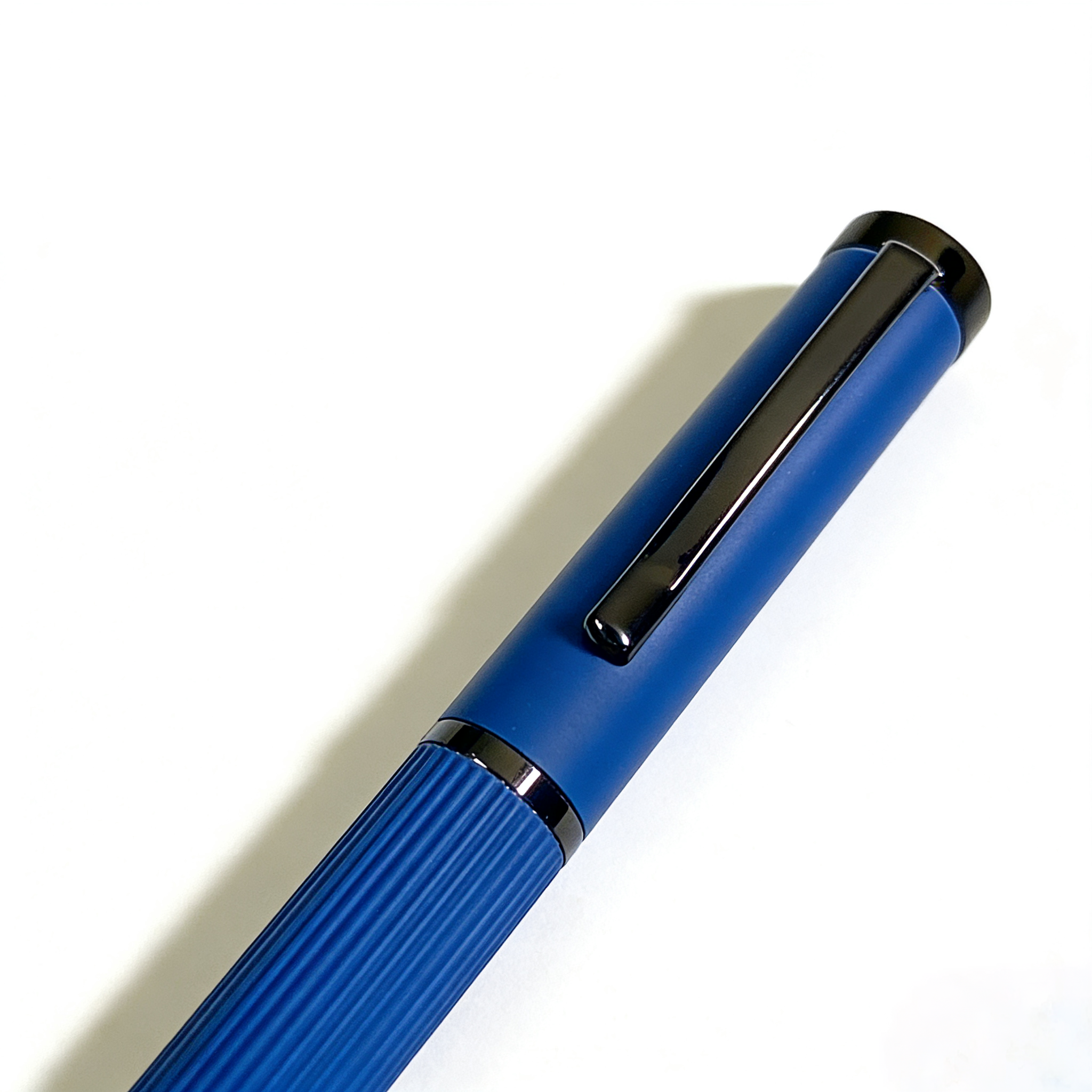 Blue pen with black clip on a white background